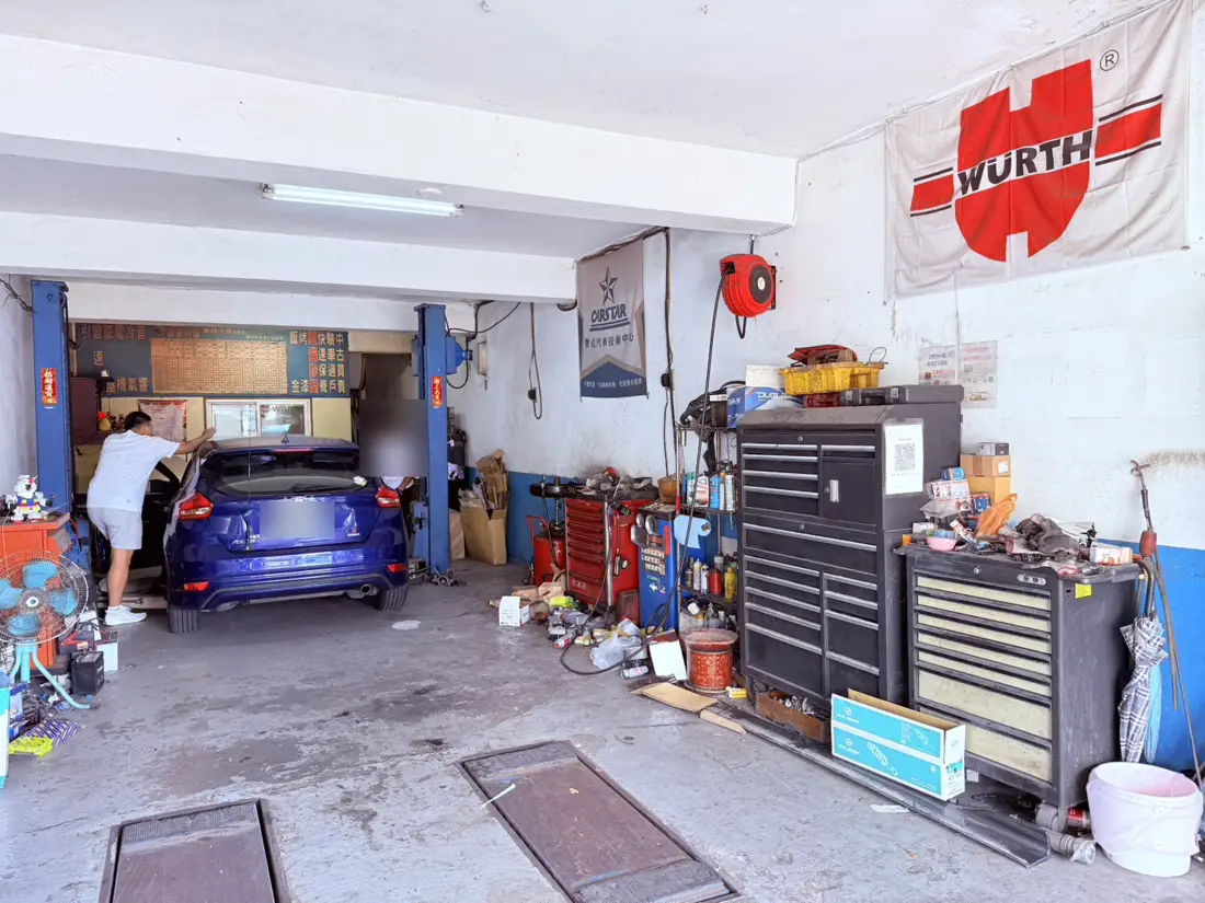 業峰汽車保養廠工作區的舉升機與工具車